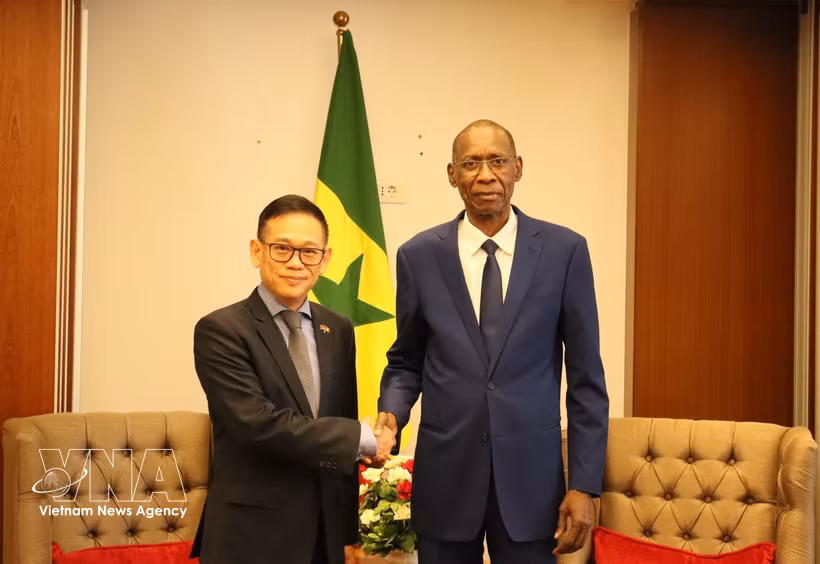 塞内加尔非洲一体化、外交和海外侨民事务部部长谢赫·尼昂与越南驻阿尔及利亚大使兼驻塞内加尔大使陈国庆亲切握手。图自越通社