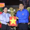 胡志明市团市委书记、胡志明市越南青年联合会主席吴明海向烈士家属移交烈士遗像。图自 muctim.tuoitre.vn