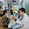 西贡眼科医院的医生为胡志明市春和坊的居民进行诊疗。图自越通社