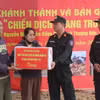 越南公安部机动警察司令部第三业务培训与职业教育中心副主任范文福上校（右二）在该中心官兵为阮廷家庭新建的住房举行落成交接后，向上德乡的阮廷一家赠送礼物并表示祝贺。图自越通社