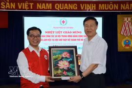 胡志明市红十字会主席阮明日向中共中央社会工作部副部长赵世堂赠送纪念品。图自越通社