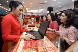人们在孟海保信金店排队买黄金。图自越通社
