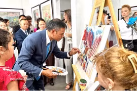 画家吴德煌在8月15日的展览现场演示在鼠皮纸上作画。图：越通社发