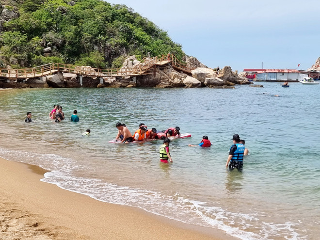 游客在庆和省永海乡永希湾的海滩游泳。图自越通社 anh-3.jpg