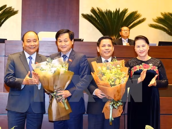  政府总理阮春福（左一）和国会主席阮氏金银（右一）向阮文体和黎明慨赠送鲜花。（图片来源：越通社） 