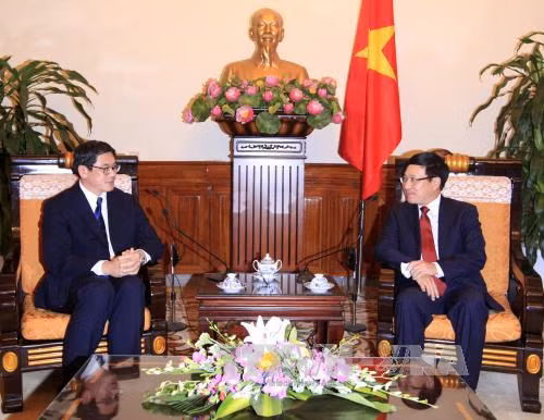 越共中央政治局委员、政府副总理兼外交部长范平明会见即将离任前来辞行拜会的新加坡驻越南大使伍德贤。（图片来源：越通社）