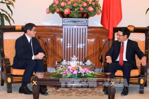  越共中央政治局委员、政府副总理兼外交部长范平明会见即将离任前来辞行拜会的新加坡驻越南大使伍德贤。（图片来源：越通社）