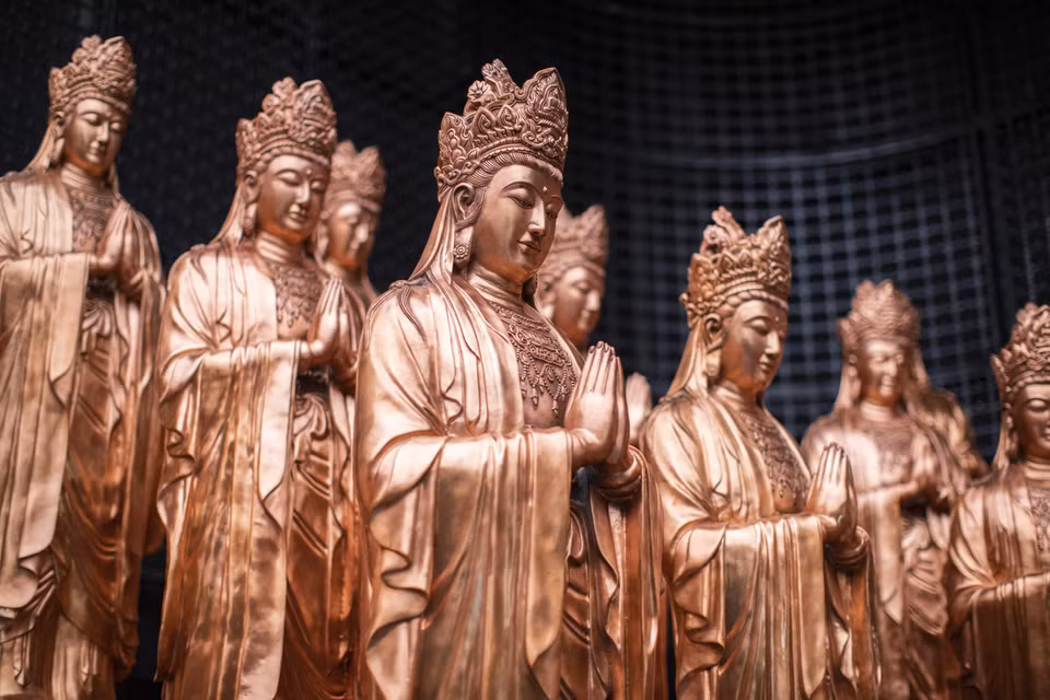 西补陀山佛像脚下是一座大寺庙，里面供奉着许多佛像。图自越通社