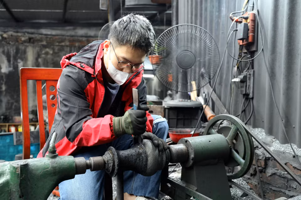 决平煤炭美术制作厂的工匠们纯手工雕刻花瓶。图自越通社