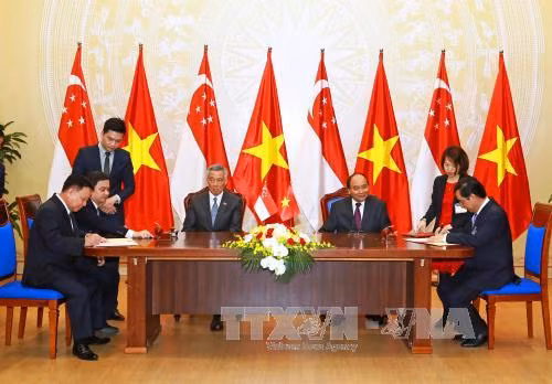 阮春福与李显龙见证广治省人民委员会与越南工业投资与越南工业投资发展有限责任公司（BECAMEX）和胜科工业集团之间的联营公司关于发展越新工业、城市和服务综合区（VSIP）的谅解备忘录签署仪式。（图片来源：越通社） 