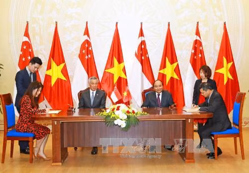 越南政府总理阮春福与新加坡总理李显龙见证新加坡国际基金会与越新友好协会合作备忘录的签署仪式。（图片来源：越通社）