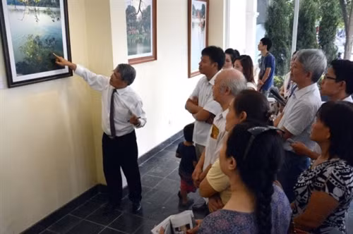 “还剑湖色彩”图片展吸引不少游客前来参观。这些日子，摄影记者河鸿经常到场为参观者仔细介绍每一张照片。本次图片展将于10月19日结束。（图片来源：vnexpress.net）
