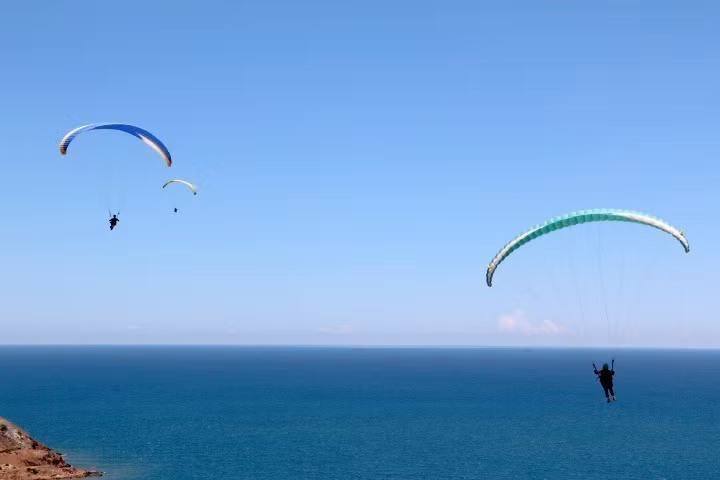 滑翔伞飞行者不仅可从高空观赏自然美景， 而且还满足自己的探险的兴趣。图自越通社