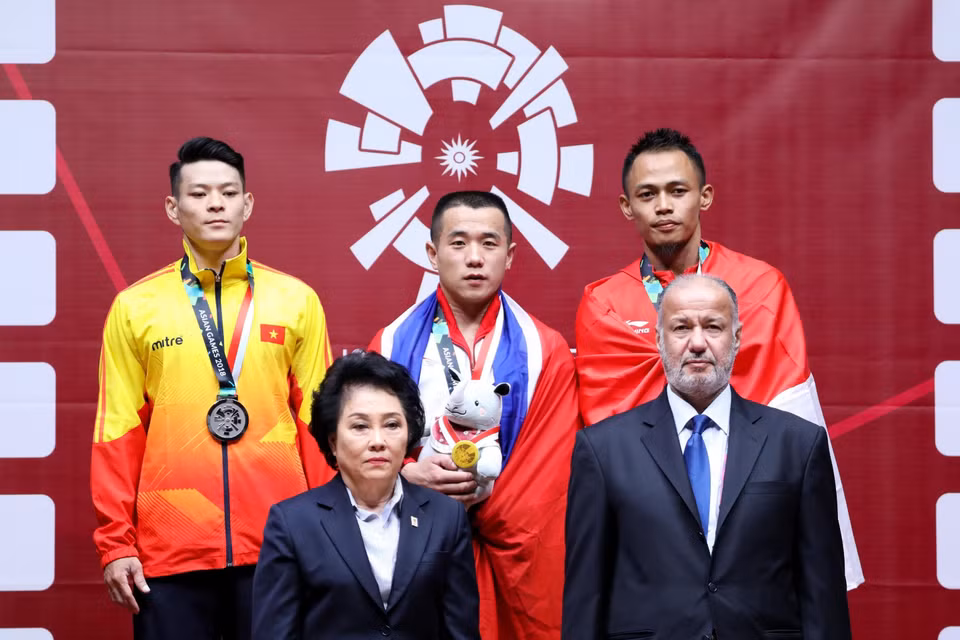 8月20日，越南举重运动员石金俊（左一）获得男子举重56公斤级银牌。图自越通社