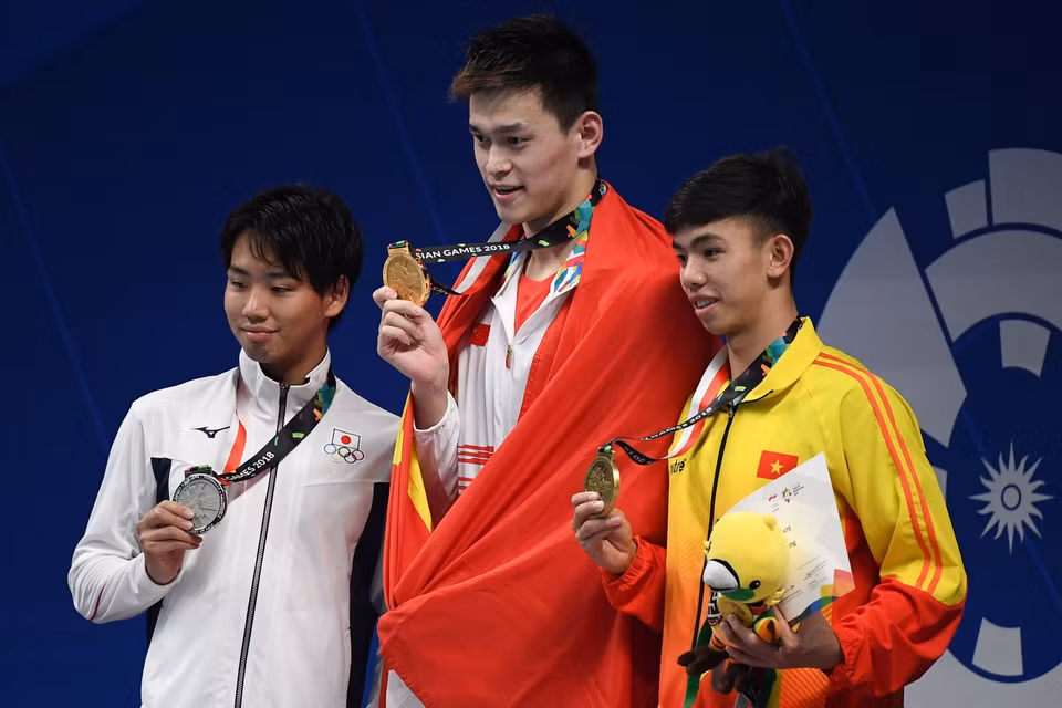 游泳运动员阮辉煌（右一）获得男子800米自由泳铜牌。图自越通社