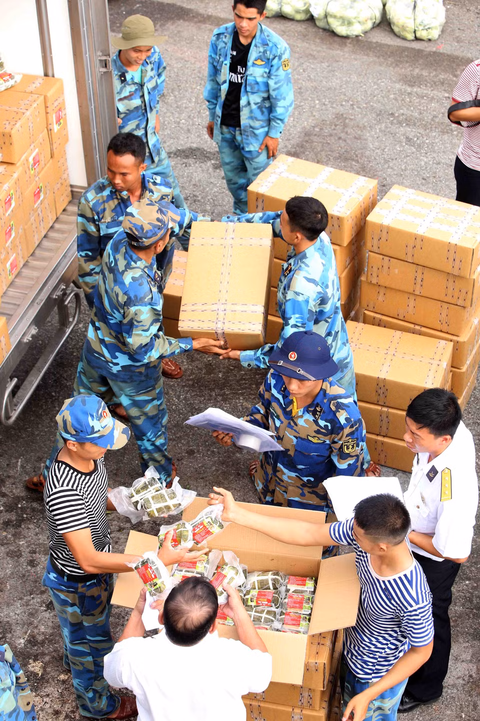 146旅战士一起将货品搬到到船上。越通社记者 邓军 摄
