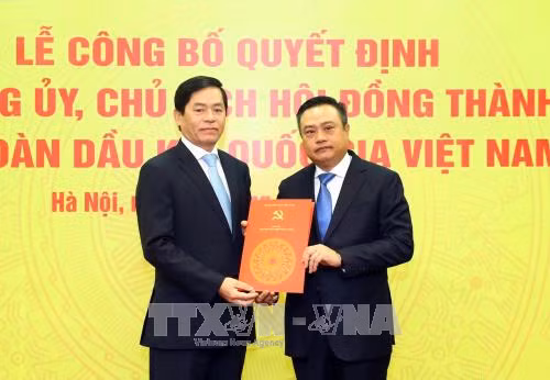  越共中央委员、中央直属企业党委书记范曰青向越南油气集团党委书记兼集团董事会主席陈士青颁发任命决定书。（图片来源：越通社）