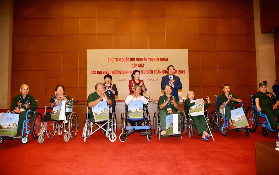 国会主席阮氏金银向全国模范伤残军人代表赠送慰问品。图自越通社