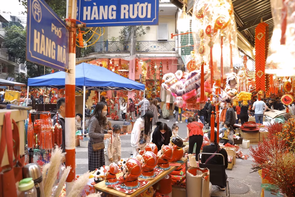 几天来，在梳行、薯行、马行、朱虫行和冯兴壁画街摆满各种鲜花、桃花、金桔、装饰品、古董和丝绸花等。图自越通社
