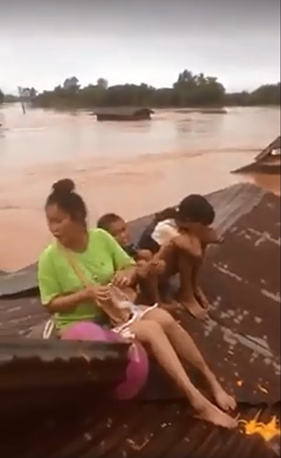 当地民众在屋顶上等待救援。（图片来源：越通社）