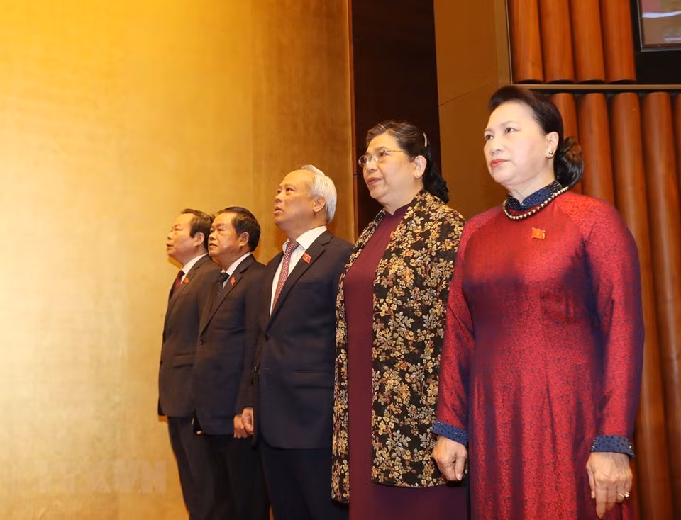 越南国会主席阮氏金银和各位国会副主席向国旗敬礼。图自越通社