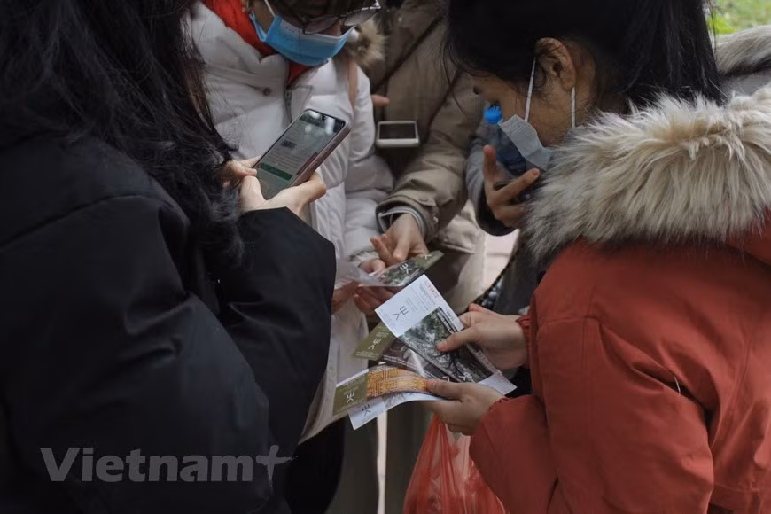 许多家庭让孩子去求字，意在让孩子了解该习俗的意义并祈求好运。在河内文庙国子监胡文区，小朋友们专注于书法家每个笔画。求字活动体现求字者对新一年的愿望。为了防疫安全，书法家们均带上口罩，在河内文庙国子监胡文区的书法家正专心写字。图自Vietnam+