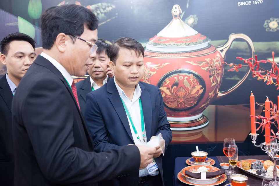参展者欣赏明隆陶瓷器。（图片来源：越通社）