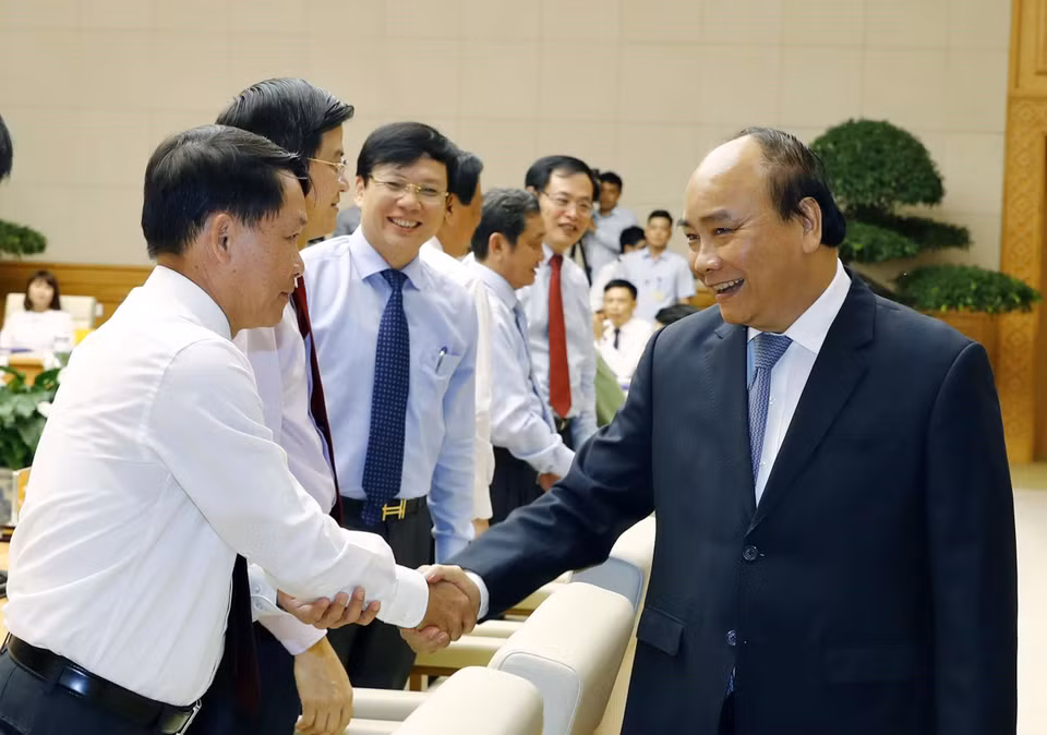  越南政府总理阮春福与越通社社长阮德利亲切握手。越通社记者 统一 摄