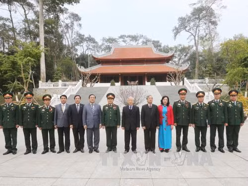  阮富仲总书记与遗迹区干部人员和战士们合影。（图片来源：越通社）