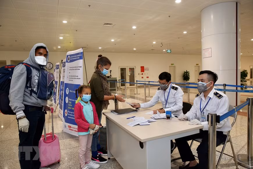 医务人员检查旅客的《健康申报表》。越通社记者 杨江 摄