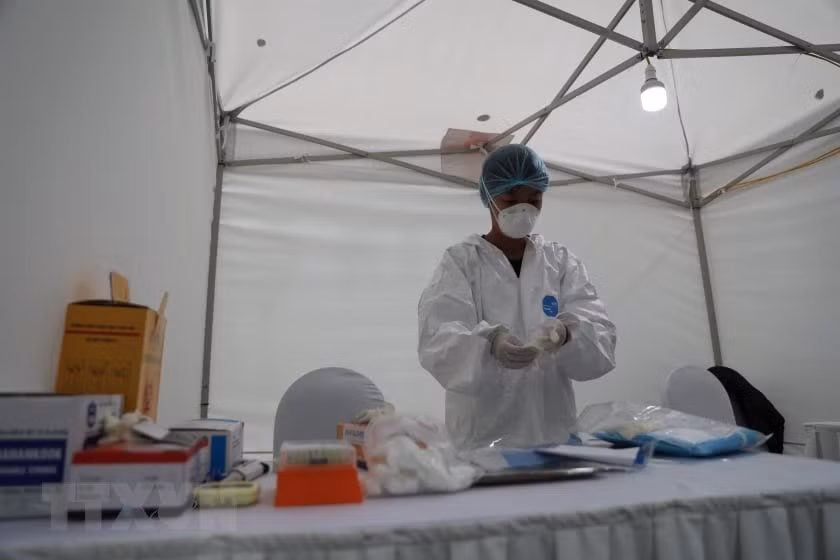 在开始工作之前，工作人员都要穿上防护服和佩戴口罩。越通社记者 青松 摄