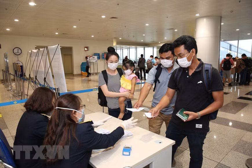 旅客向医务人员提交《健康申报表》。越通社记者 杨江 摄