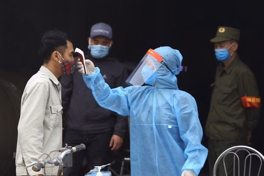 医务人员给东九村人民测量体温。越通社记者 明决 摄