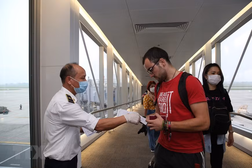医务人员检查旅客的《健康申报表》。越通社记者 杨江 摄
