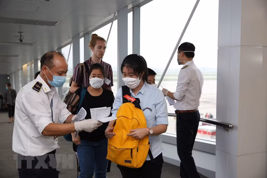 医务人员检查旅客的《健康申报表》。越通社记者 杨江 摄