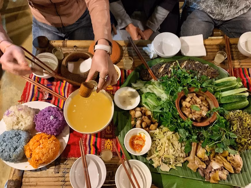 来到石碑村时夜幕已降临，村民打起锣钲迎接游客的到来并后摆着丰盛菜肴招待来宾。游客已有机会品尝了当地芒族人各种特色菜肴，如烤鱼、煮山鸡、酸竹笋凉拌菜、五色糯米饭、烤猪等。这些菜肴都是当地村民自给自足的，特有西北山区的香味。除了菜肴外，酒也是当地的特产，来到这里的游客需品尝的。喝酒后气氛将更加活跃，人们将高唱起来，跳起舞。图自Vietnam+