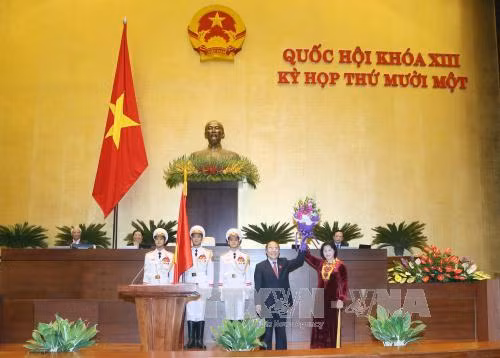 原国会主席阮生雄向新任国会主席阮氏金银赠送鲜花表示祝贺。（图片来源：越通社）