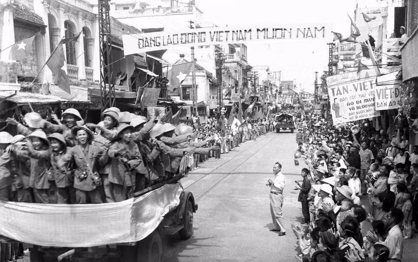1954年10月10日，在首都河内成千上万名居民充满欢乐的气氛中，先锋军308号大团部队战士在桃行街上游行。图自 越通社