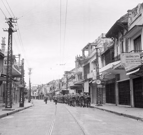 1954年10月8日， 法军进行降旗仪式，9日开始退出河内。9日16点30分，越南军接管整个城市。图中：1954年10月9日，法国步兵力量在桃行街默默退出河内。图自 越通社