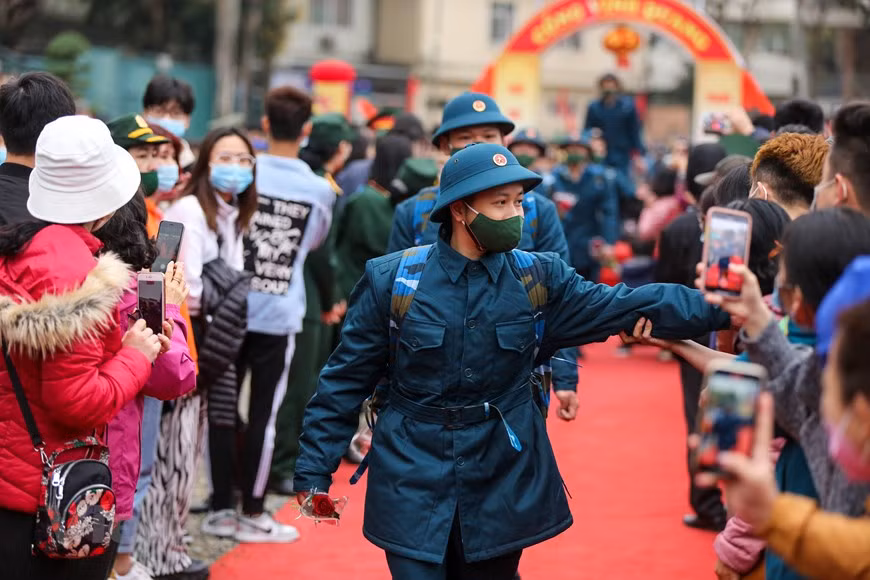 据河内首都司令部的消息，为了确保新冠肺炎疫情防控工作，在新冠肺炎疫情复杂多变的背景下，在举行新兵交接仪式举行之前，河内市已举行新冠病毒采样检测活动。新兵在正式入伍之前要进行测量体温,防止疫情输入军队，确保防疫安全。图自Vietnam+