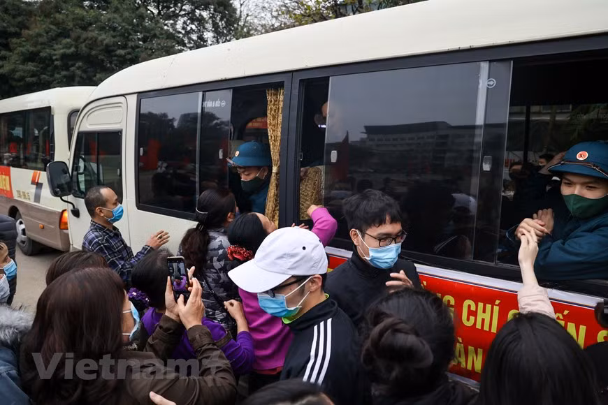 新兵正式入伍之间，必须接受最后一次体温监测。新兵都下决心完成被交给的任务，为建国卫国事业做出积极贡献。当兵光荣，但作为新世纪的青年一代，他们肩上更是担负着重大的责任。在新兵交接仪式上，河内市领导向新兵们赠送鲜花。图自Vietnam+