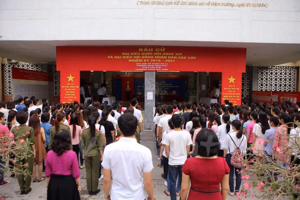越南河内师范大学大学生兴高采烈参加投票。