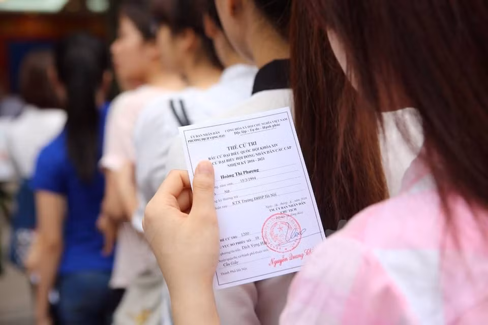越南河内师范大学大学生兴高采烈参加投票。