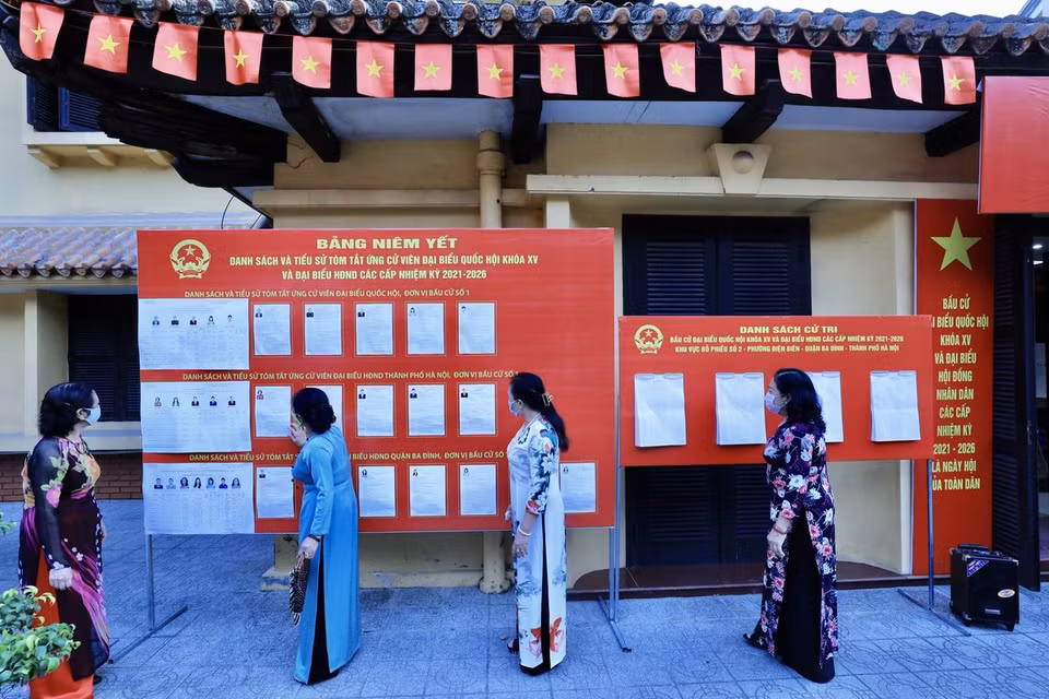 选民在河内市巴亭郡奠边坊2号投票站查阅候选人名单。图自越通社