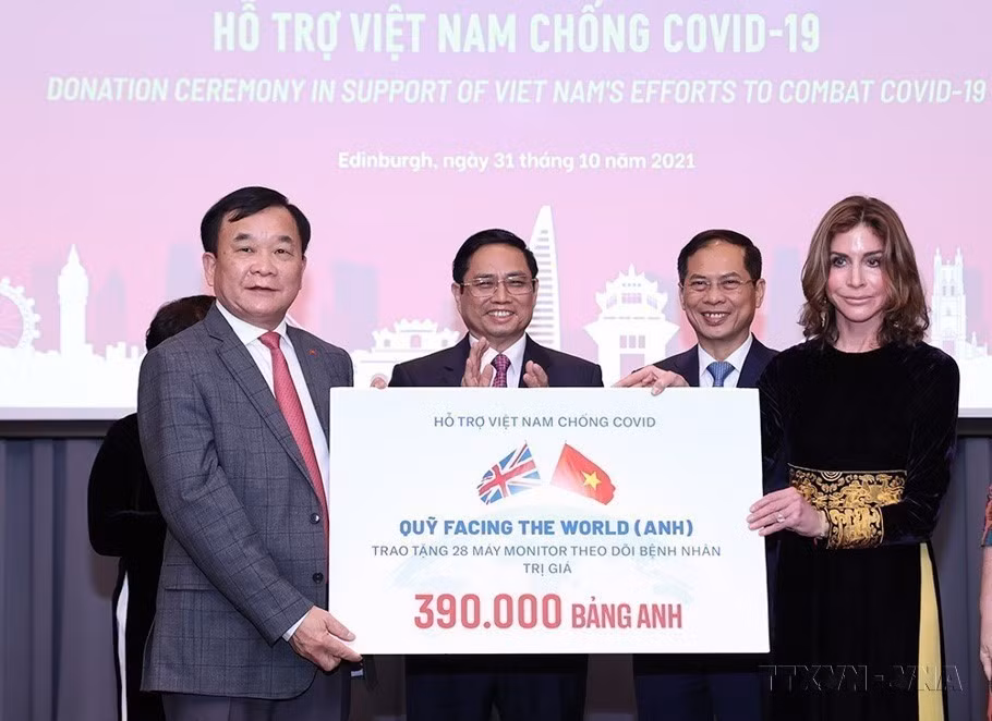 2021年在赴英进行正式访问期间，范明政总理见证了帮助越南抗新冠肺炎疫情的援助资金交接仪式。图自越通社