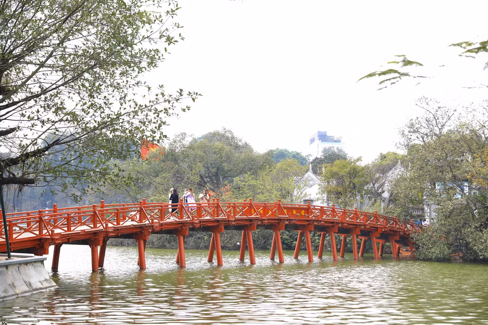 连接还剑湖和玉山寺的栖旭桥有15个桥段，下面由32根圆木柱并列而成，桥面铺木板，护栏涂刷红漆，在还剑湖碧绿的水面上显得格外醒目，引人入胜。图自越通社