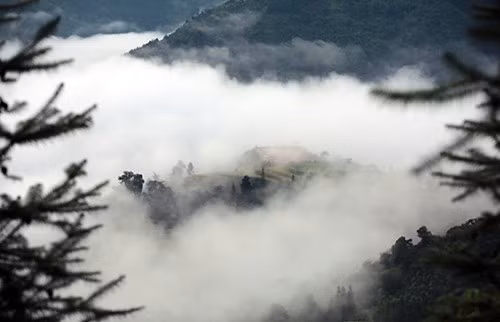山峰与白云融为一体，构成了一幅虚幻空灵的画面。（图片来源：人民军队报网）