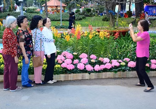 老年人与五颜六色的花朵合影留念。（图片来源：人民军队报）
