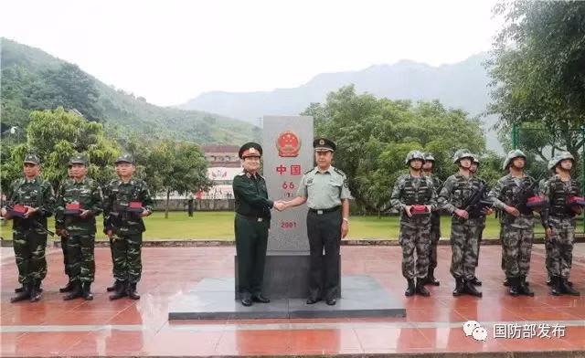 吴春历与范长龙在第66号界碑前合影。（图片来源：中国国 防部）