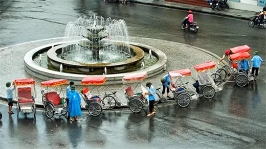 下雨天，三轮车一般穿上白色雨衣，旨在不阻碍游客视线。（图片来源：越南《人民军队报》）